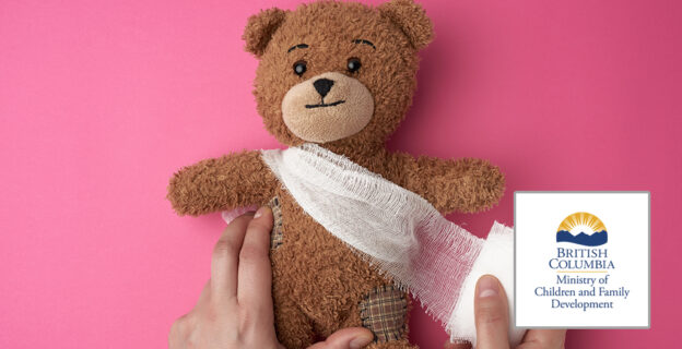 A teddy bear with white bandages wrapped around its torso. Two hands adjust the bandages. There is a British Columbia Ministry of Children and Family Development logo in the bottom right corner.